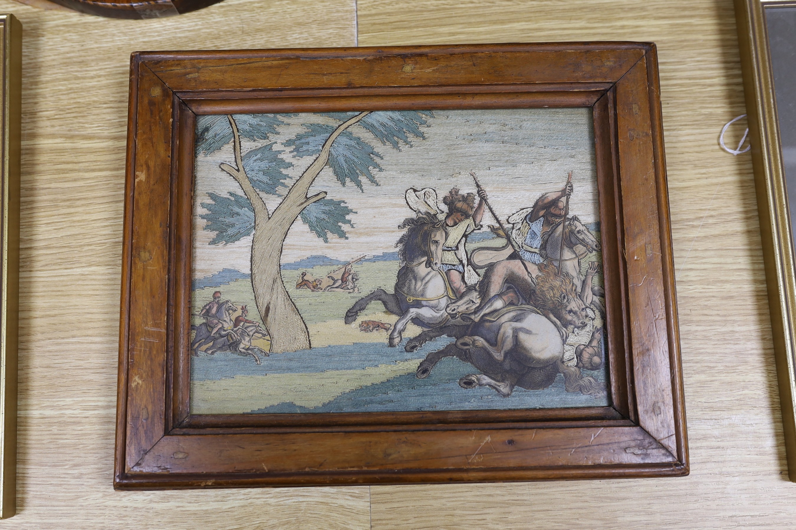 Three late 19th / early 20th century framed tapestries - a mountain scape with farmer and heard, a female figure with animal, and a with lions and men on horseback fighting scene, together with two maps - ‘Gloucestershir
